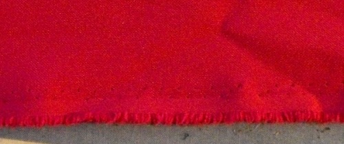 The selvage of this red fabric has tiny holes and looks different from the rest of the fabric.