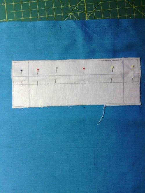 Put pins through the dots on the garment interfacing to mark where the pocket goes on the right side.  Put the welt on the garment, right sides together.  Pin it like this.